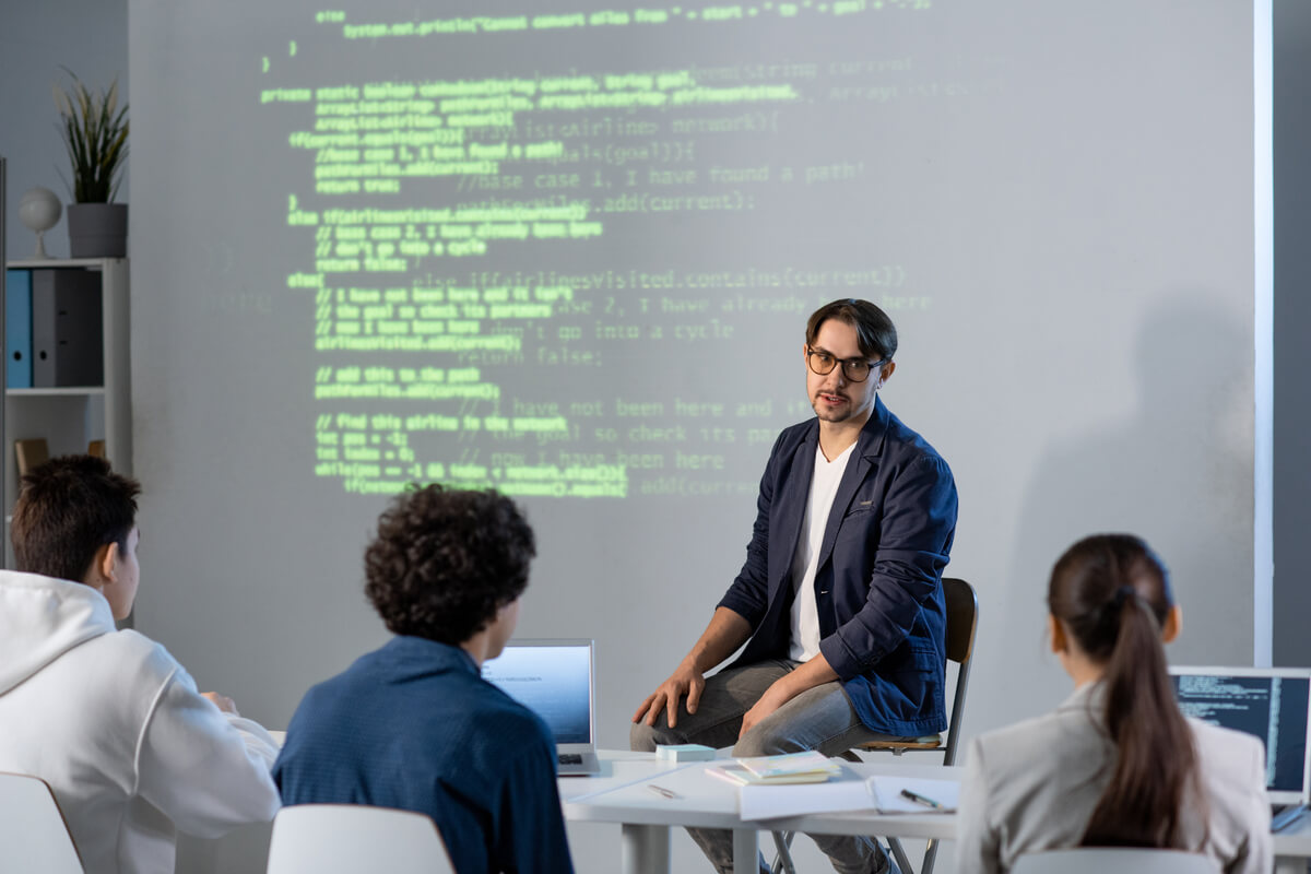 young confident teacher explaining his students in GNDAGGA.jpg